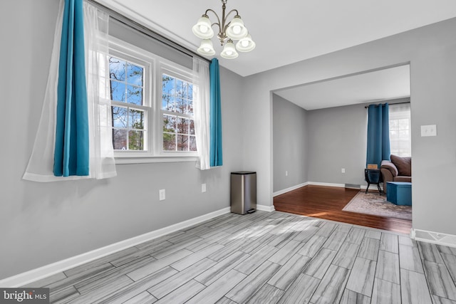 interior space with a notable chandelier, baseboards, and wood tiled floor