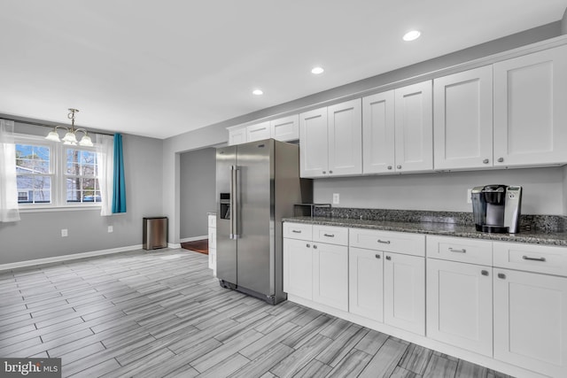 kitchen with white cabinets, baseboards, recessed lighting, high quality fridge, and an inviting chandelier
