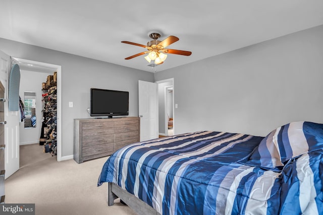 bedroom featuring light carpet, baseboards, and ceiling fan