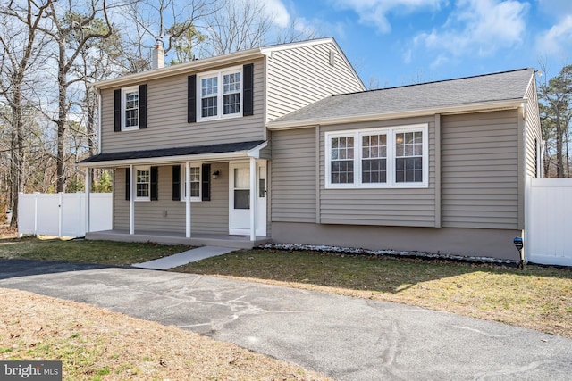 traditional home with covered porch and fence