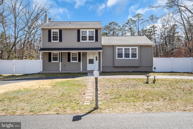 traditional-style home with a gate, fence, and a front lawn