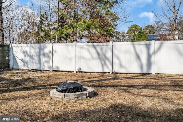 view of yard featuring an outdoor fire pit and fence