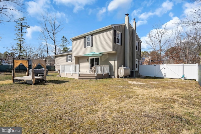 back of property with a gate, fence, a wooden deck, a lawn, and cooling unit