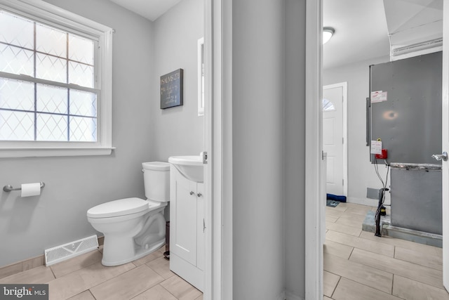 bathroom with baseboards, visible vents, toilet, and vanity