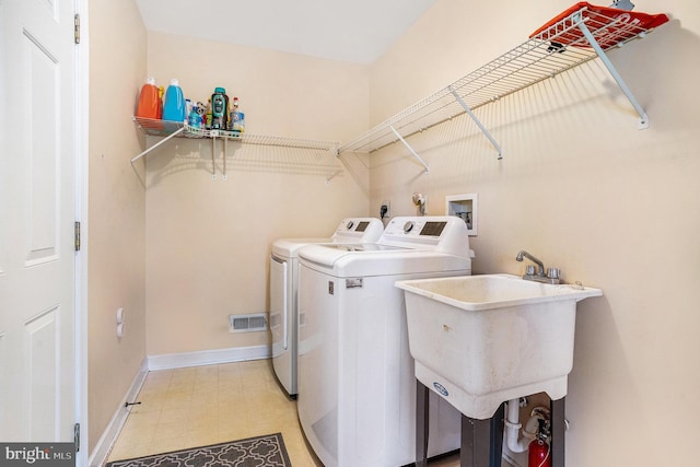 washroom featuring laundry area, light floors, independent washer and dryer, visible vents, and a sink