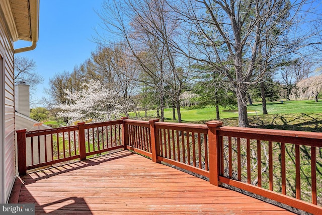 wooden deck featuring a lawn