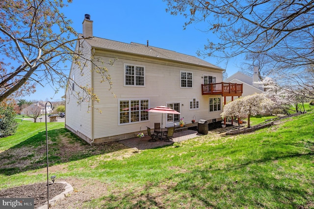 back of property with a patio area, a lawn, and a chimney