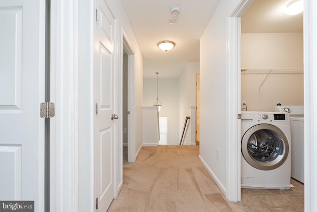laundry area with washer / dryer, baseboards, light colored carpet, and laundry area