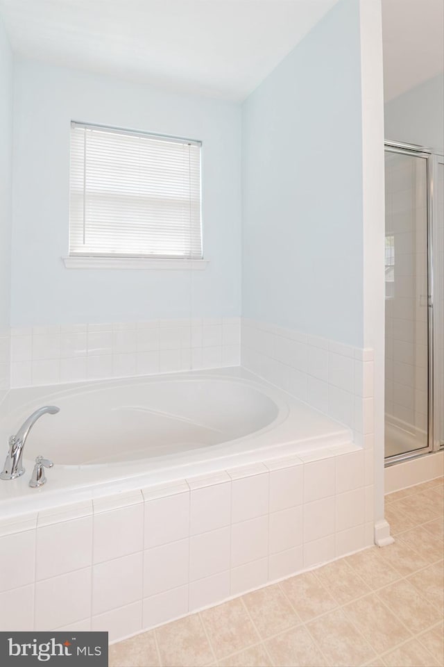 bathroom featuring a bath, tile patterned floors, and a shower stall