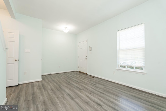 unfurnished room featuring baseboards and wood finished floors