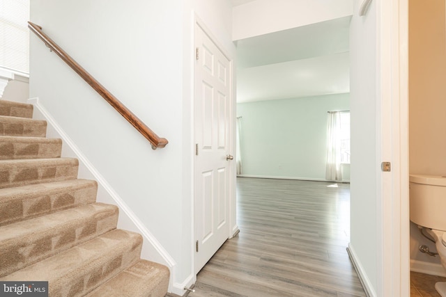 stairway featuring baseboards and wood finished floors