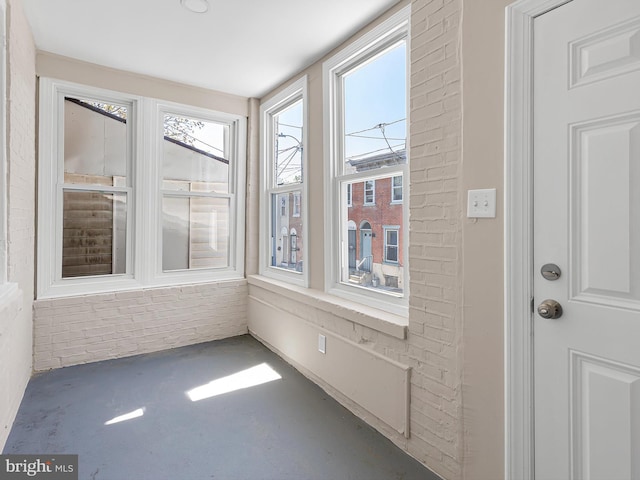 unfurnished sunroom featuring concrete floors