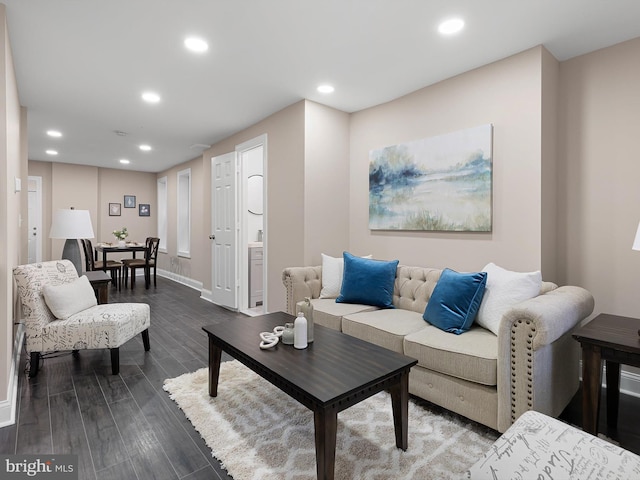 living room featuring dark wood finished floors, baseboards, and recessed lighting