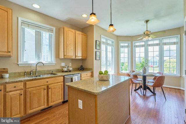 kitchen with a sink, dishwasher, a healthy amount of sunlight, and light brown cabinetry