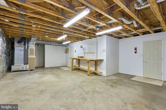 below grade area featuring heating unit and a workshop area
