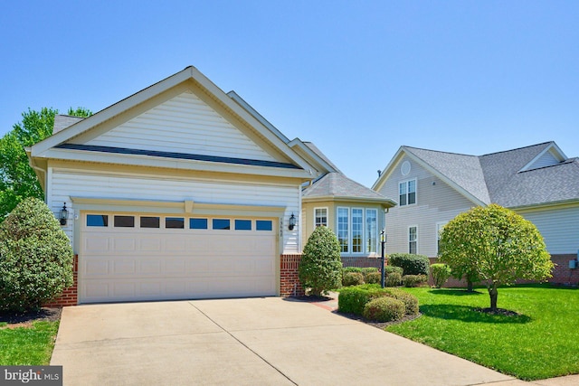 view of front of home featuring a garage, concrete driveway, a front yard, and brick siding