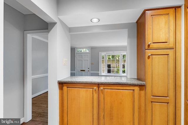 544 N Saint Asaph St, Alexandria, VA 22314 - kitchen featuring brown cabinetry, light stone counters, wood finished floors, and baseboards