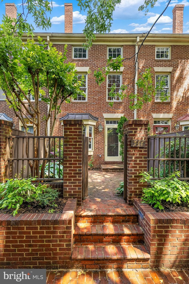 544 N Saint Asaph St, Alexandria, VA 22314 - view of front of property with brick siding, fence, and a chimney