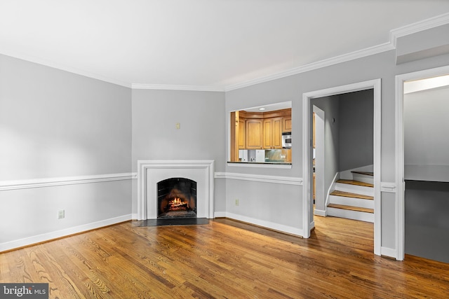 544 N Saint Asaph St, Alexandria, VA 22314 - unfurnished living room featuring wood finished floors, a lit fireplace, ornamental molding, baseboards, and stairway