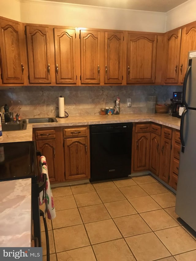 kitchen with black appliances, crown molding, tasteful backsplash, and light countertops