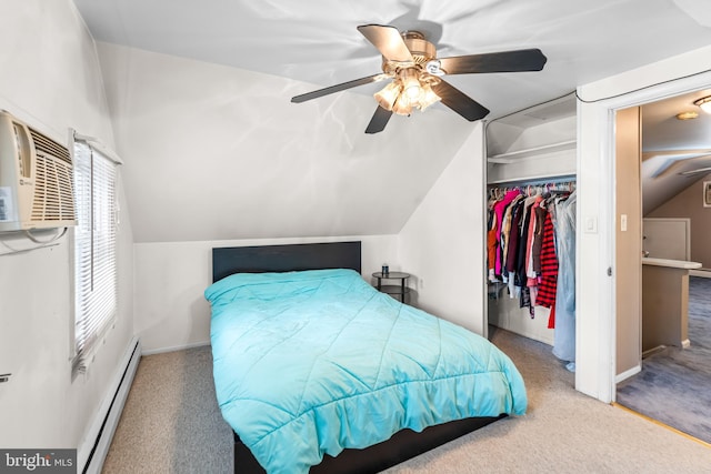 carpeted bedroom with a baseboard heating unit, lofted ceiling, a closet, and a ceiling fan