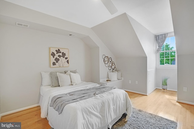 bedroom featuring wood finished floors, baseboards, and lofted ceiling