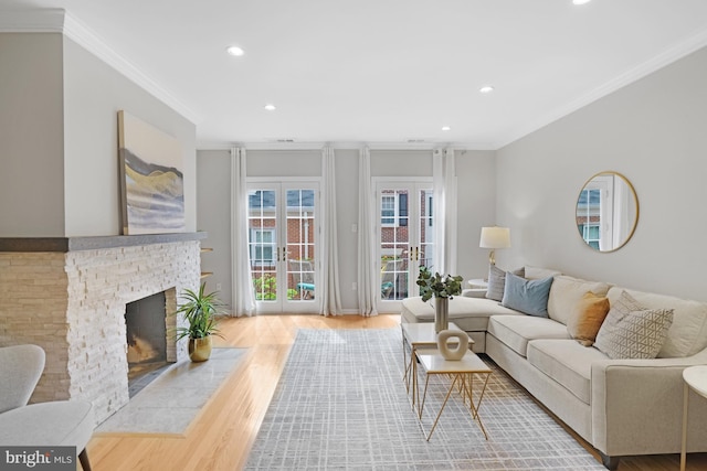 living area featuring wood finished floors, recessed lighting, ornamental molding, and a fireplace with flush hearth