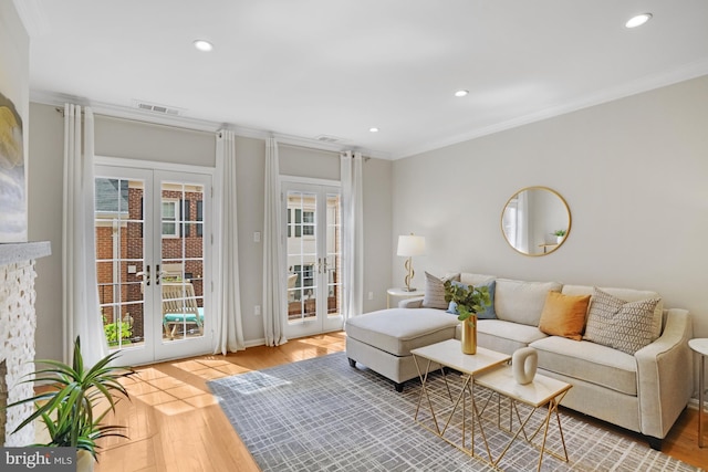 living area with french doors, wood finished floors, crown molding, recessed lighting, and baseboards