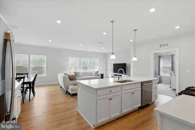 kitchen with visible vents, open floor plan, stainless steel appliances, and a sink
