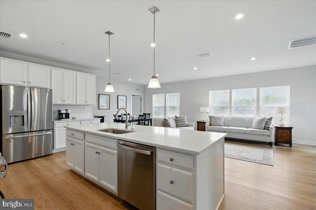 kitchen featuring a sink, visible vents, white cabinetry, light countertops, and appliances with stainless steel finishes