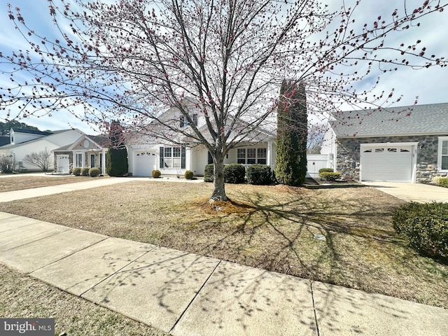 view of front of house featuring stone siding, an attached garage, and concrete driveway