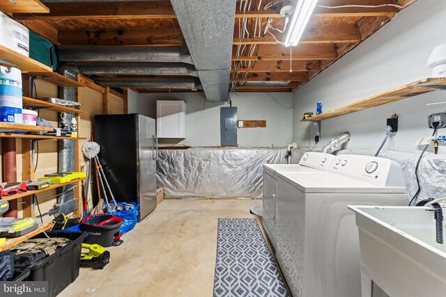clothes washing area with a sink, laundry area, independent washer and dryer, and electric panel