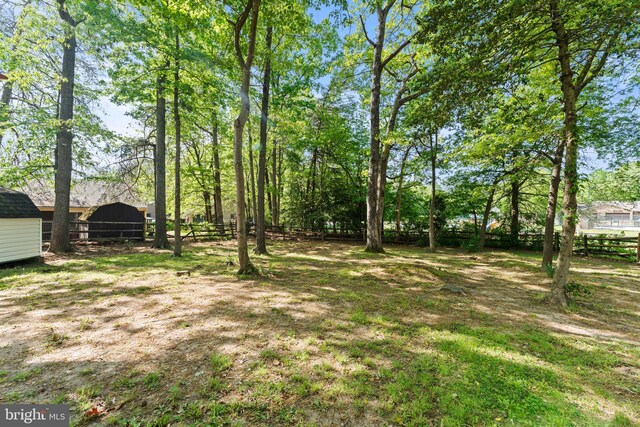 view of yard featuring fence and an outdoor structure