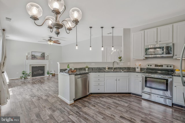 11587 Wollaston Cir, Swan Point, MD 20645 - kitchen with stainless steel appliances, a sink, a peninsula, ceiling fan, and wood finished floors