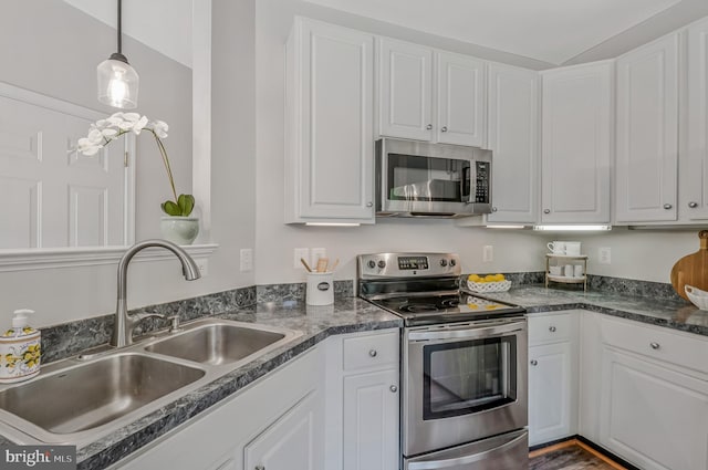 11587 Wollaston Cir, Swan Point, MD 20645 - kitchen featuring appliances with stainless steel finishes, a sink, dark countertops, white cabinetry, and decorative light fixtures