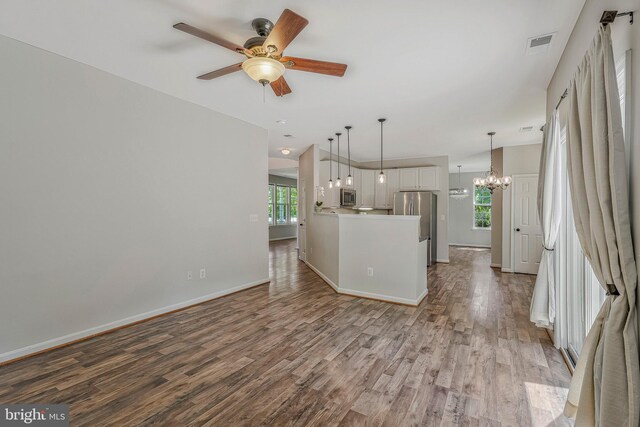 11587 Wollaston Cir, Swan Point, MD 20645 - unfurnished living room featuring wood finished floors, a ceiling fan, a chandelier, and baseboards