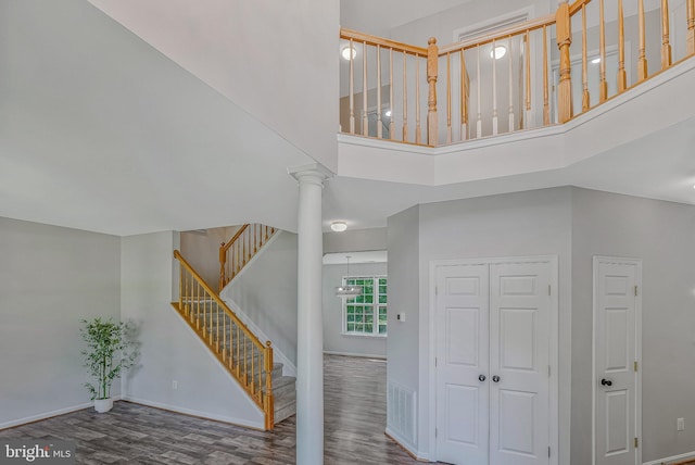 11587 Wollaston Cir, Swan Point, MD 20645 - staircase featuring wood finished floors, a high ceiling, baseboards, and decorative columns