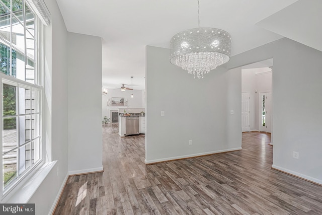 11587 Wollaston Cir, Swan Point, MD 20645 - unfurnished dining area featuring a chandelier, wood finished floors, ceiling fan, baseboards, and a towering ceiling