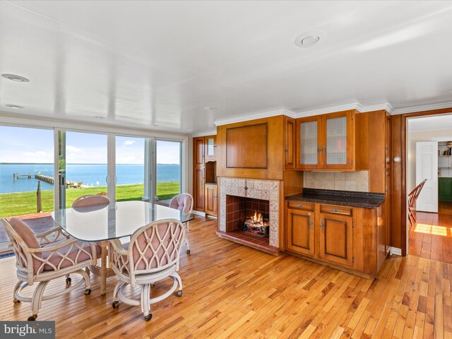 5917 Horns Point Rd, Cambridge, MD 21613 - dining room with a fireplace, light wood-type flooring, ornamental molding, and a water view