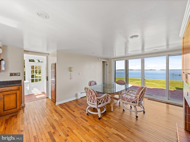 5917 Horns Point Rd, Cambridge, MD 21613 - dining room with plenty of natural light, a water view, light wood finished floors, and a baseboard heating unit