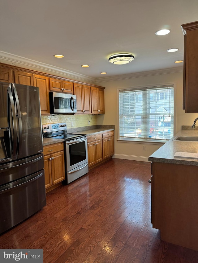 961 Rue Madora, Bear, DE 19701 - kitchen with dark wood-type flooring, a sink, ornamental molding, and appliances with stainless steel finishes