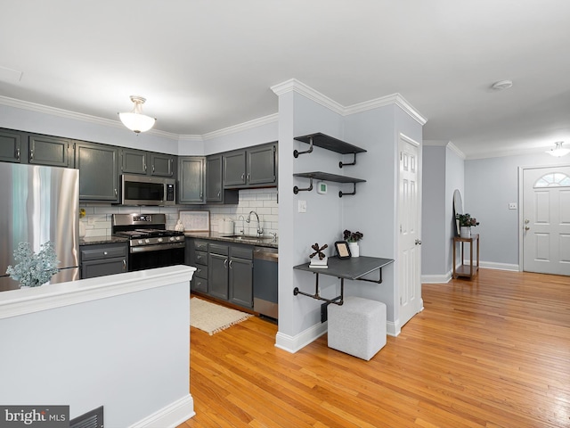 998 Glackens Ln, Wilmington, DE 19808 - kitchen featuring stainless steel appliances, light wood-type flooring, a sink, tasteful backsplash, and crown molding