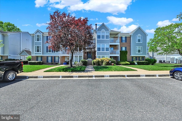 multi unit property featuring brick siding and uncovered parking