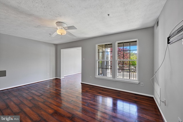 empty room with ceiling fan, a textured ceiling, visible vents, wood finished floors, and baseboards