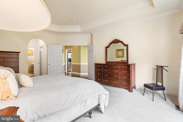 bedroom featuring light colored carpet, a raised ceiling, ornamental molding, and arched walkways