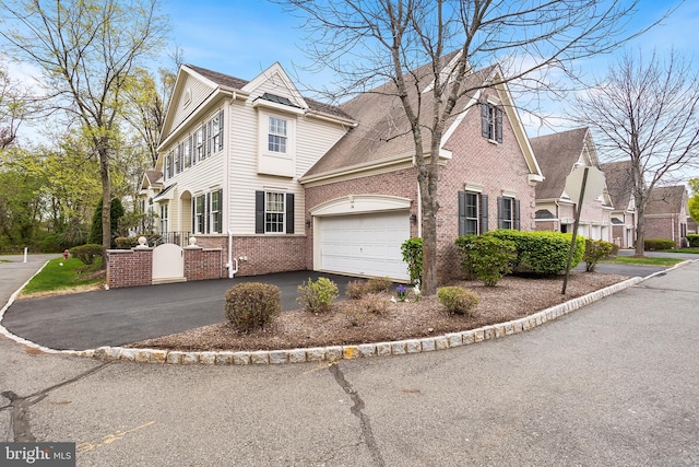 view of property exterior featuring driveway, an attached garage, and brick siding
