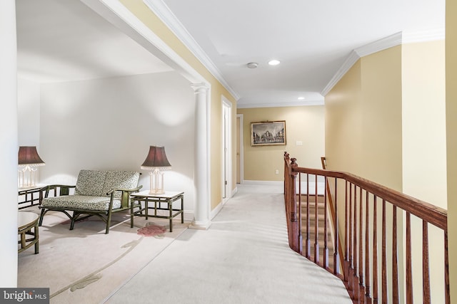 corridor with ornate columns, an upstairs landing, baseboards, ornamental molding, and carpet floors
