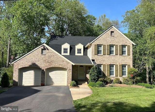 view of front of property with a shingled roof, an attached garage, brick siding, a front yard, and driveway