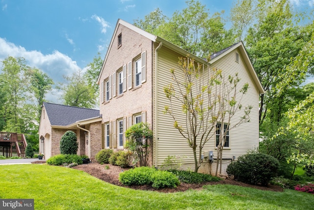 view of home's exterior with brick siding and a yard