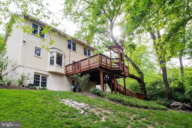back of house featuring a lawn, a deck, and stairway